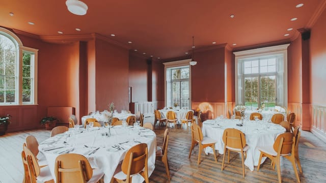 Elegant dining room with round tables, ideal for weddings and corporate events.