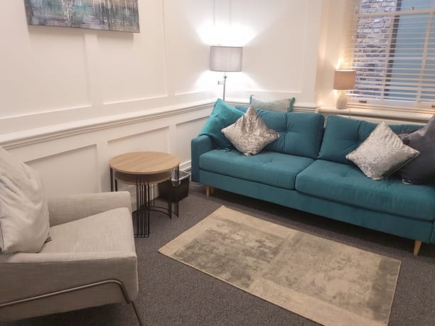 Cozy meeting space with teal sofa for informal discussions and networking events.
