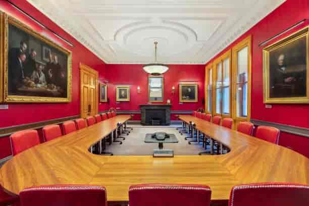 Elegant boardroom with red walls, ideal for executive meetings and strategic planning.
