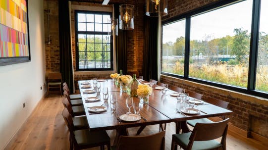 Private dining room with long wooden table, perfect for upscale meetings and events.
