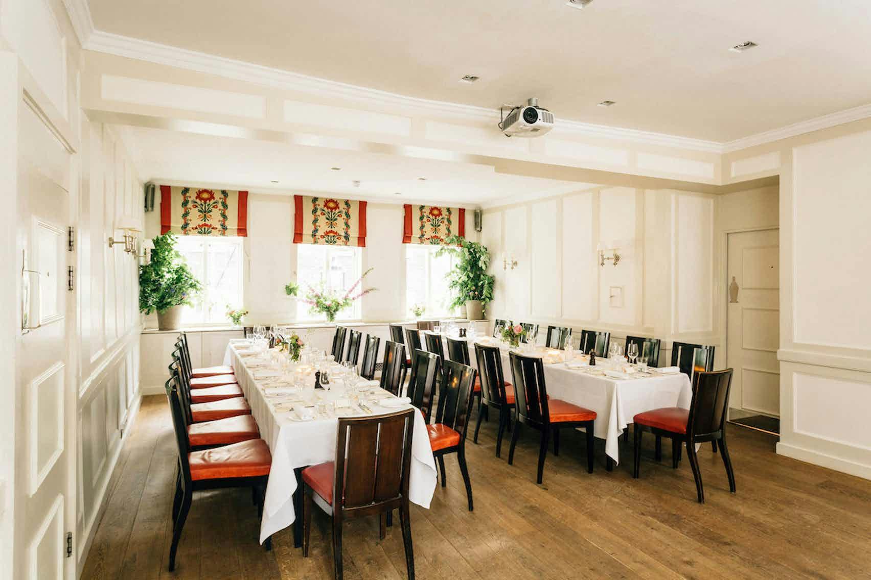 Elegant meeting room with long table, natural light, perfect for workshops and presentations.