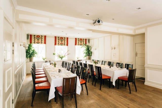 Elegant meeting room with long table, natural light, perfect for workshops and presentations.