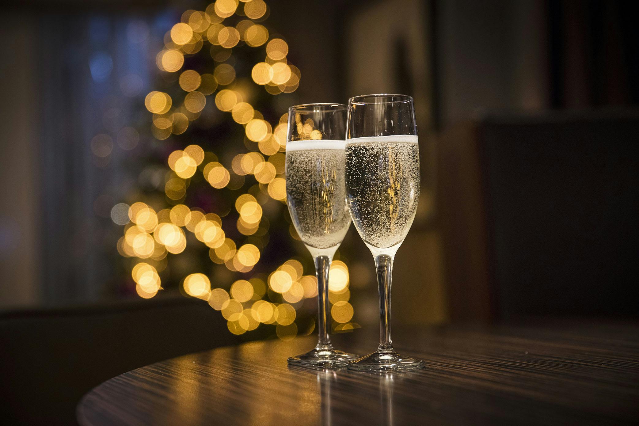 Champagne flutes with holiday lights, perfect for festive celebrations and gatherings.