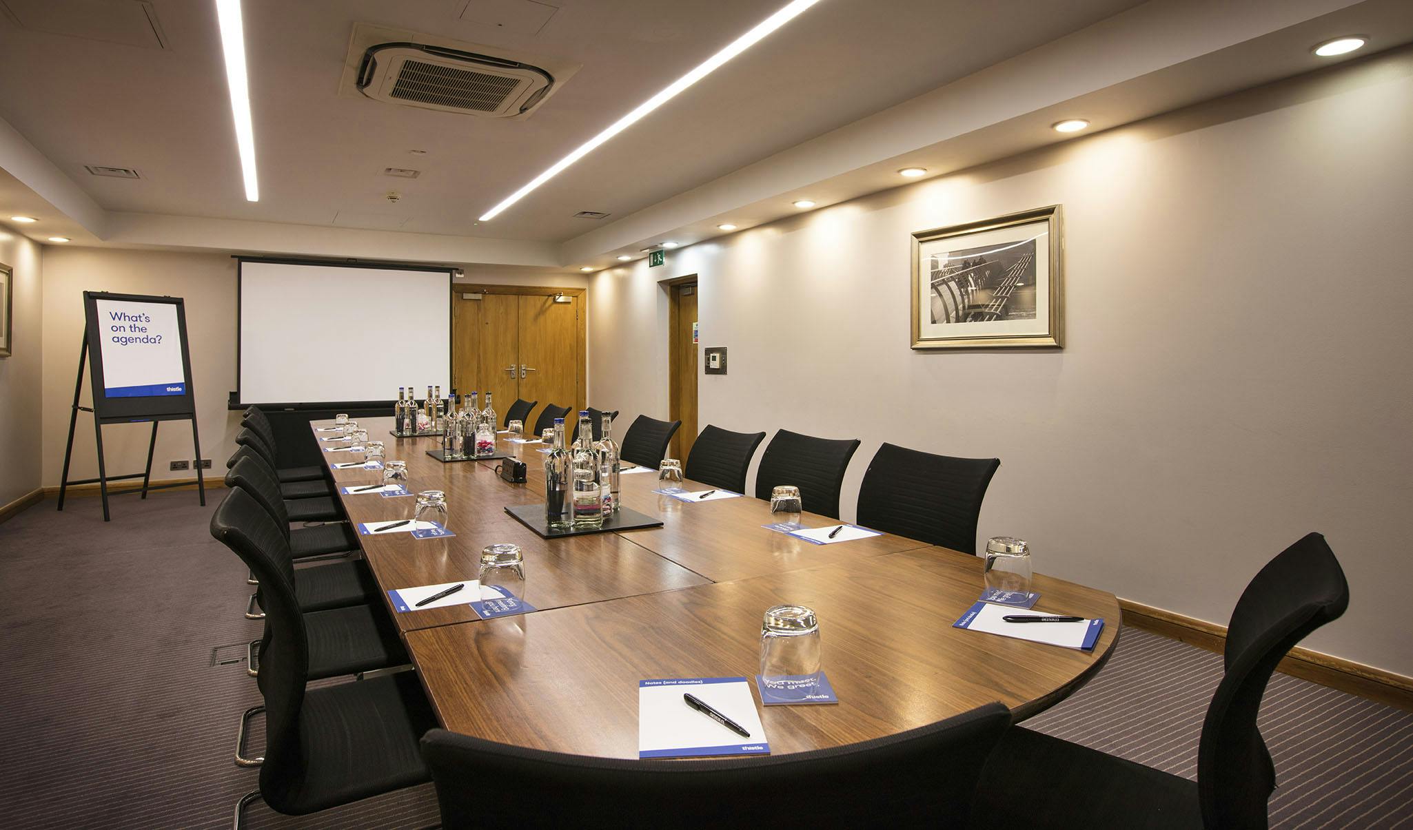 Meeting room at Fitzroy Thistle Holborn with wooden table, ideal for professional gatherings.