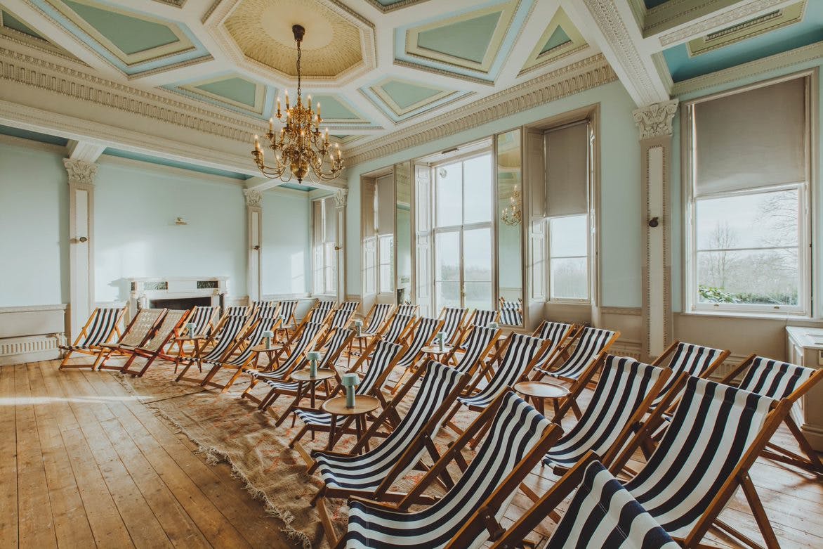 Stylish screening room with striped deck chairs for creative workshops and events.