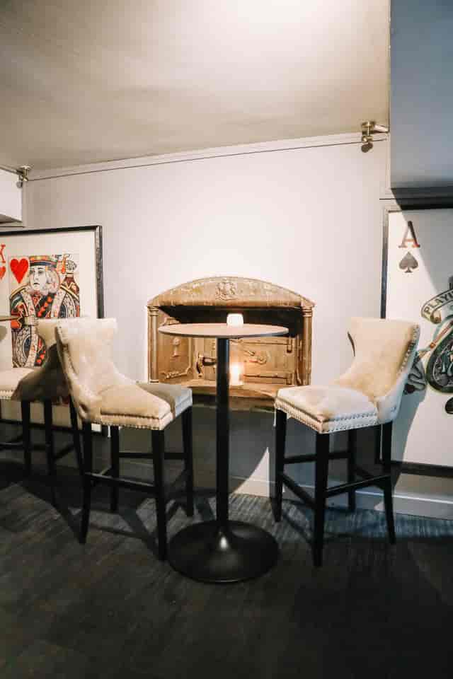 Intimate meeting space at Sandy's Piano Bar with plush chairs and artistic decor.