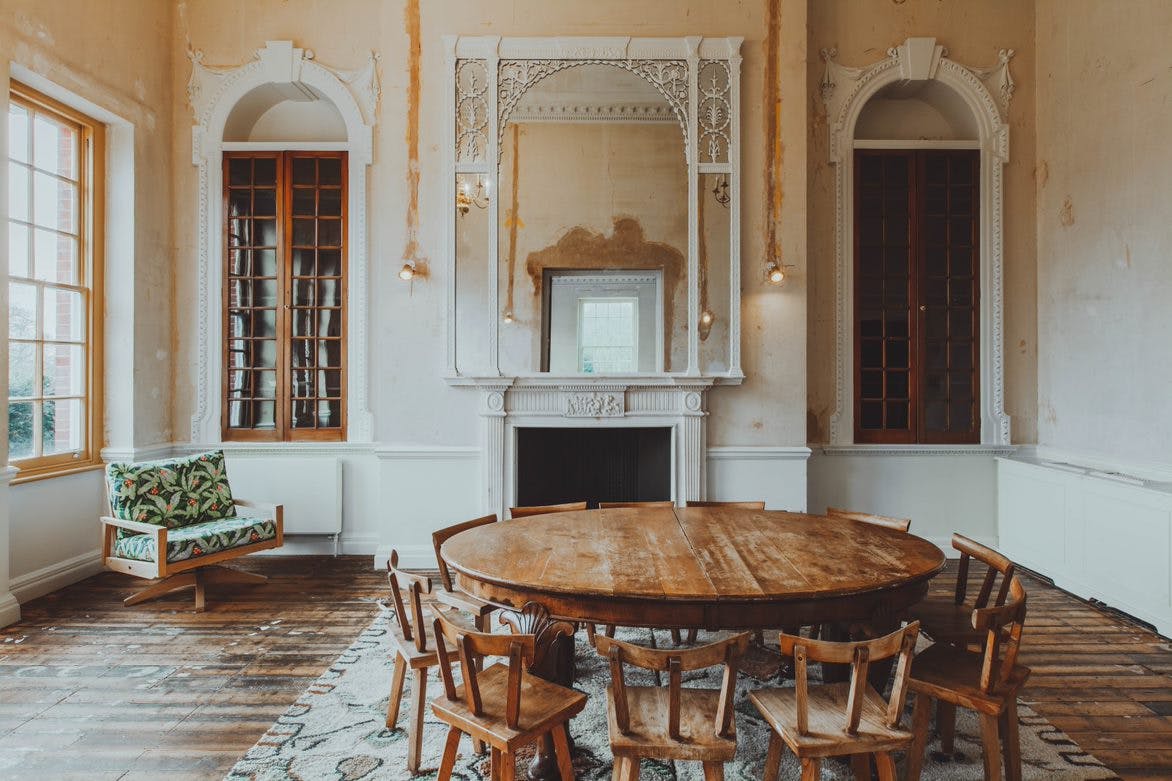 Charming meeting space with wooden table, rustic chairs for gatherings and workshops.