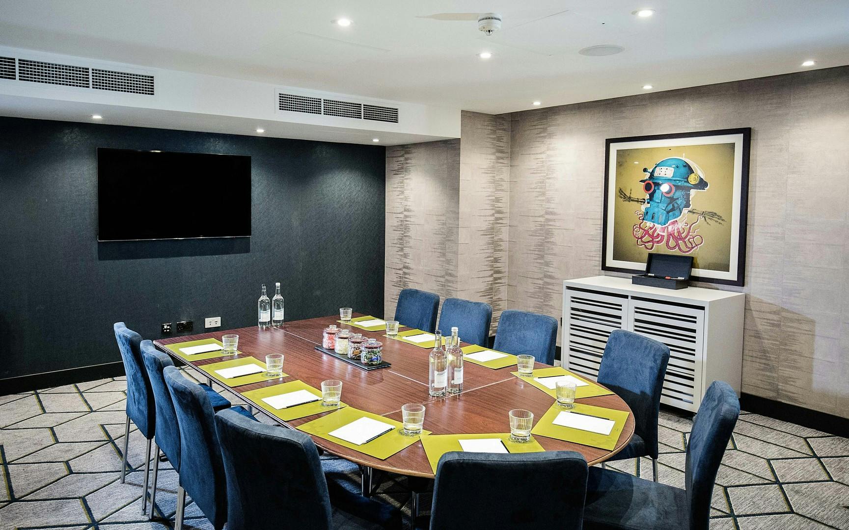 Meeting room with oval table, ideal for professional gatherings and brainstorming sessions.