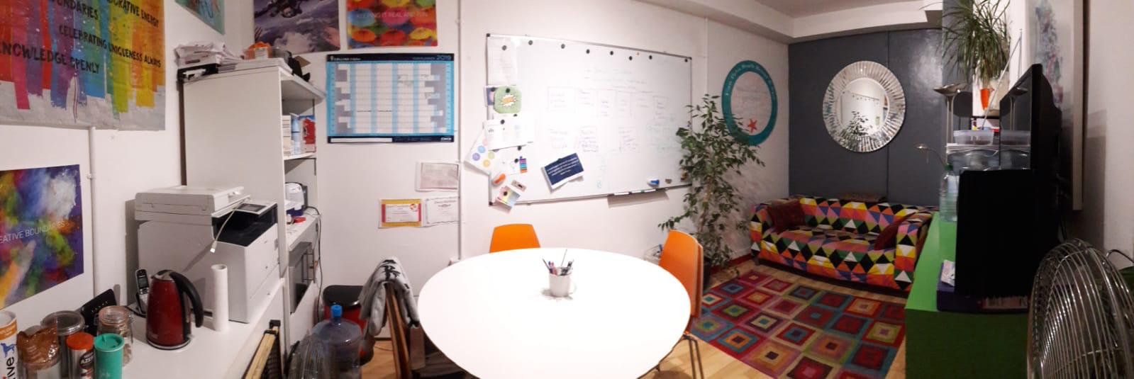 Cozy meeting room with round table, ideal for brainstorming and team discussions. - Banner