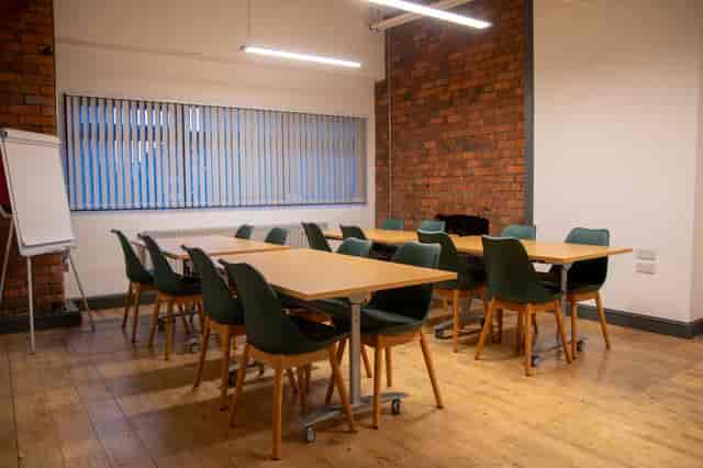 Versatile meeting space with wooden floors, ideal for workshops and brainstorming sessions.