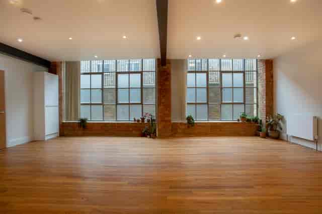 Spacious event space with large windows and wooden flooring at Chocolate Studios.