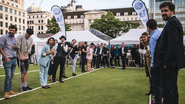 Vibrant outdoor event at Festibowl with tents, flags, and a diverse crowd for networking.