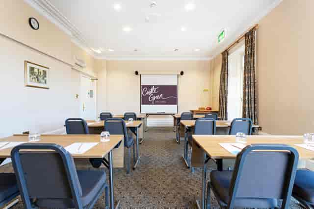 Garden Room at Castle Green Hotel, featuring a projector screen for meetings and workshops.