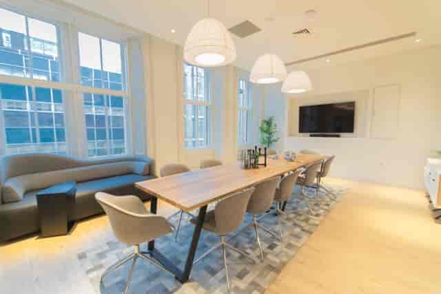 Modern meeting room at Mackintosh, featuring a large wooden table for collaborative events.