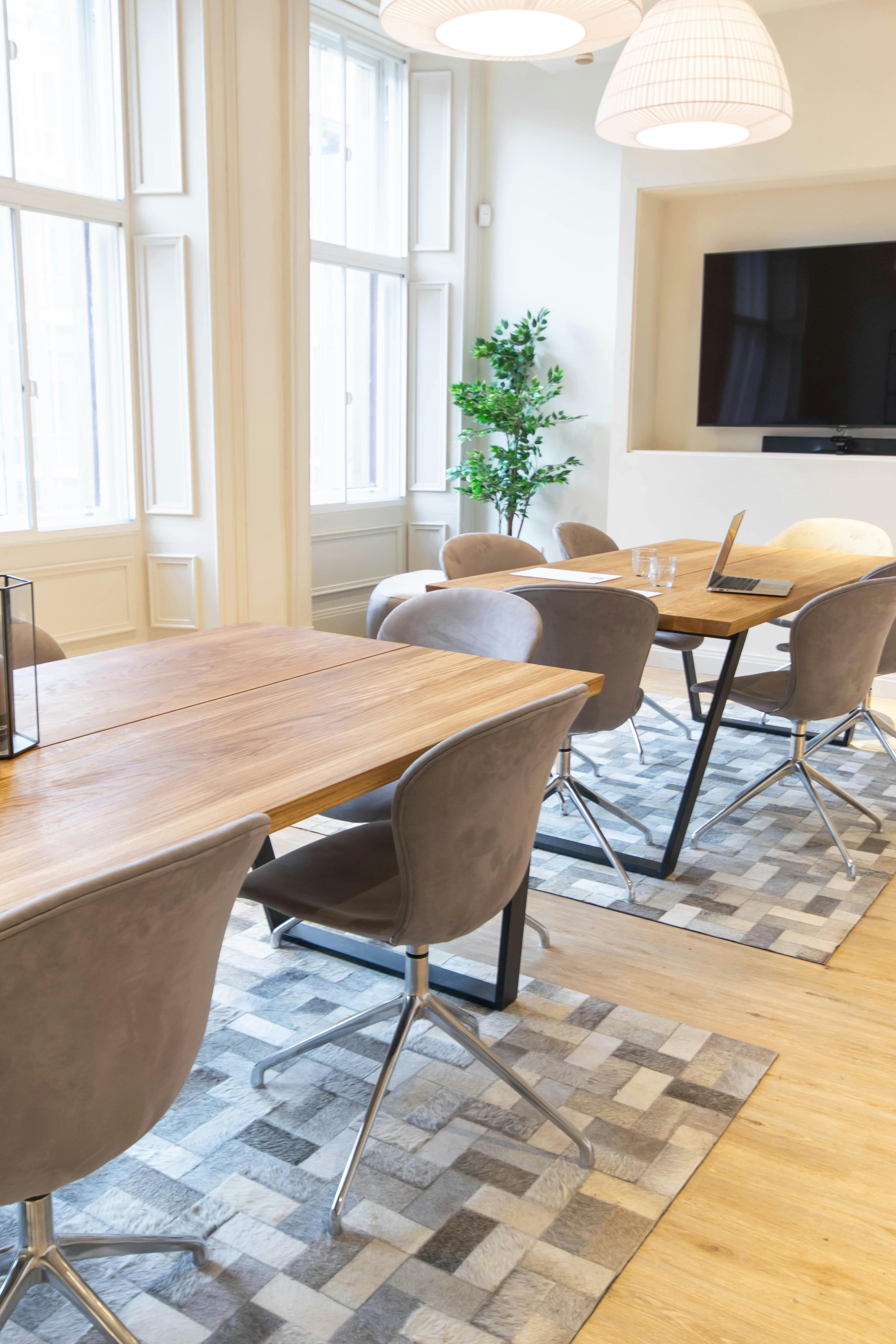 Modern meeting space at Mackintosh with wooden tables, ideal for workshops and team meetings.