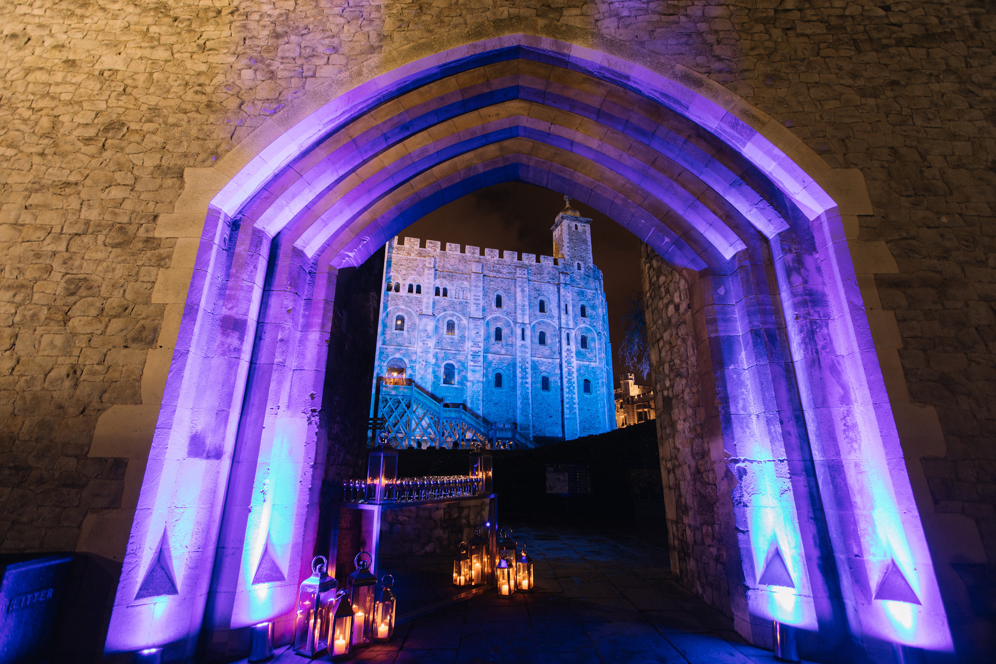 New Armouries entrance at Tower of London, stone archway with purple lighting for events. - Banner
