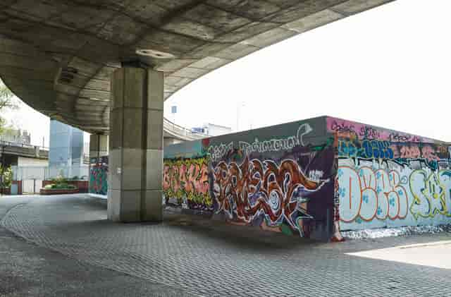 Urban graffiti art under concrete overpass at Westway Sports & Fitness Centre for events.