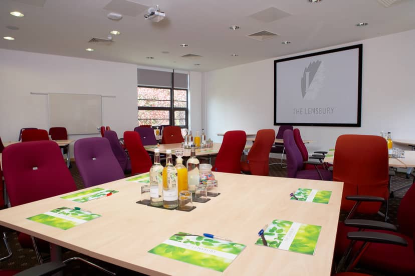 Modern meeting room with colorful chairs, ideal for workshops and strategic meetings.
