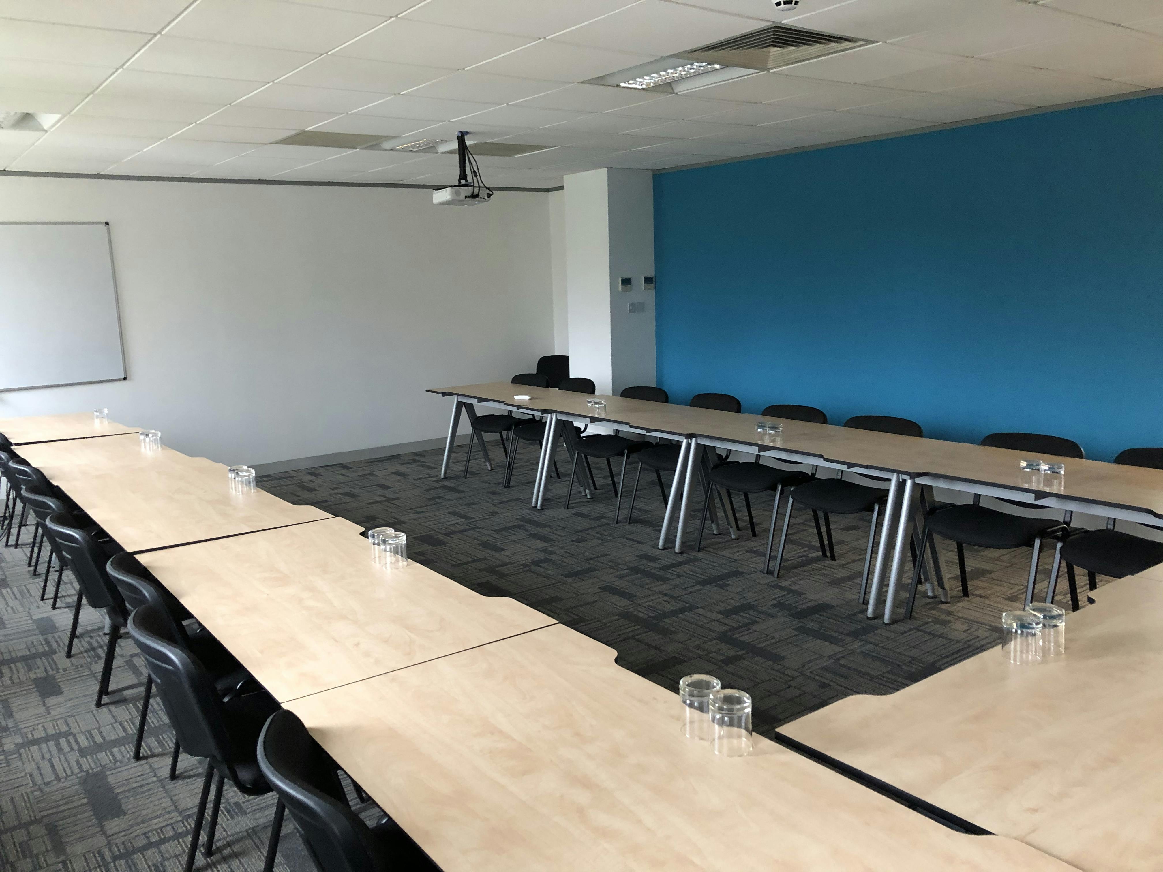 Cyan Suite meeting room at UBC, featuring a blue accent wall for collaborative sessions.