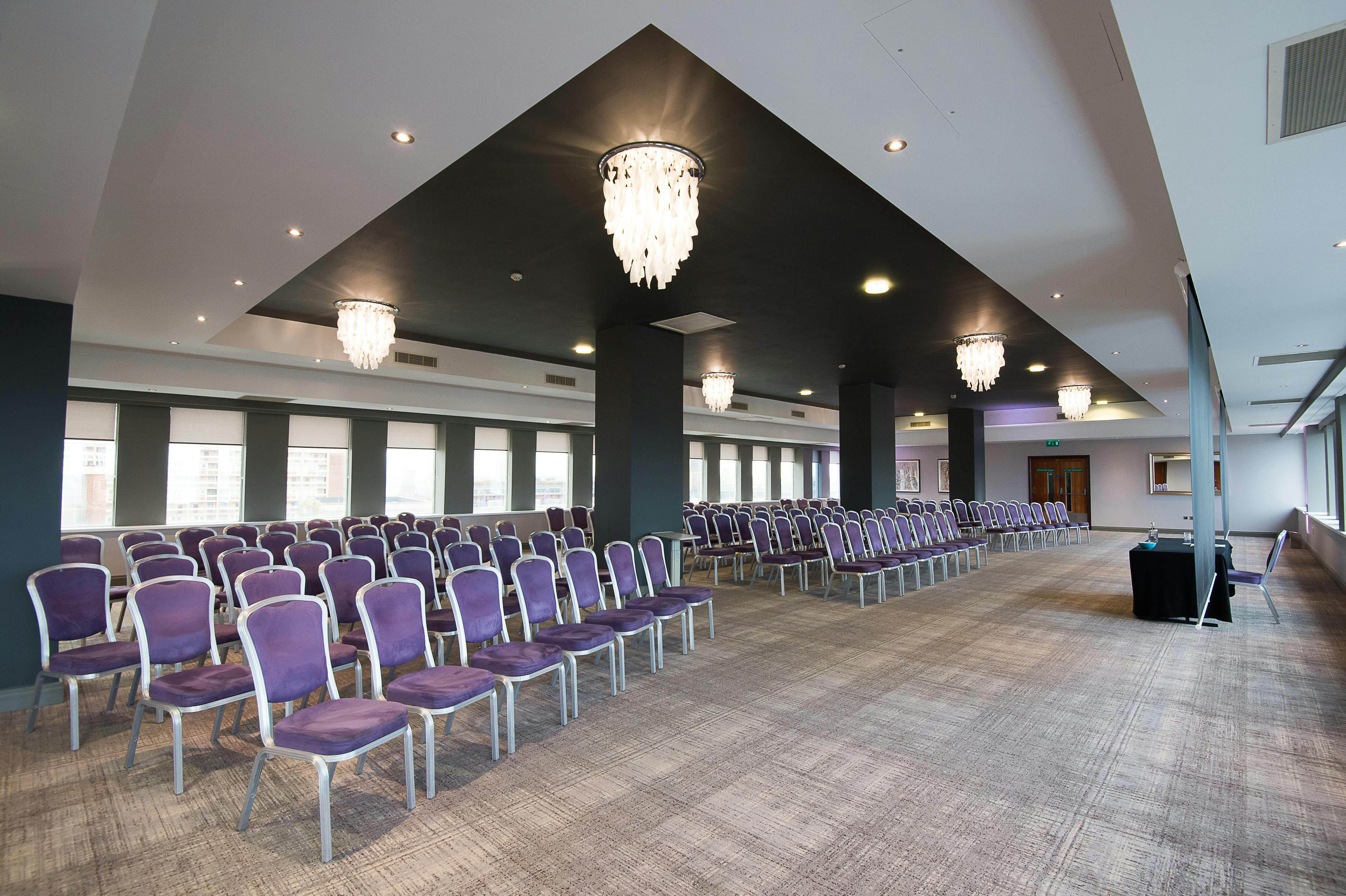 Spacious Forest Suite conference venue with elegant purple chairs and natural light.