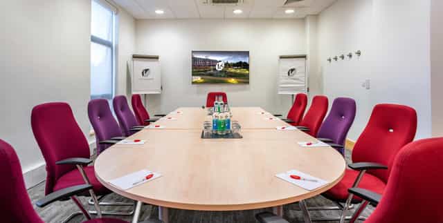 Modern conference room with oval table, ergonomic chairs for meetings at The Lensbury.