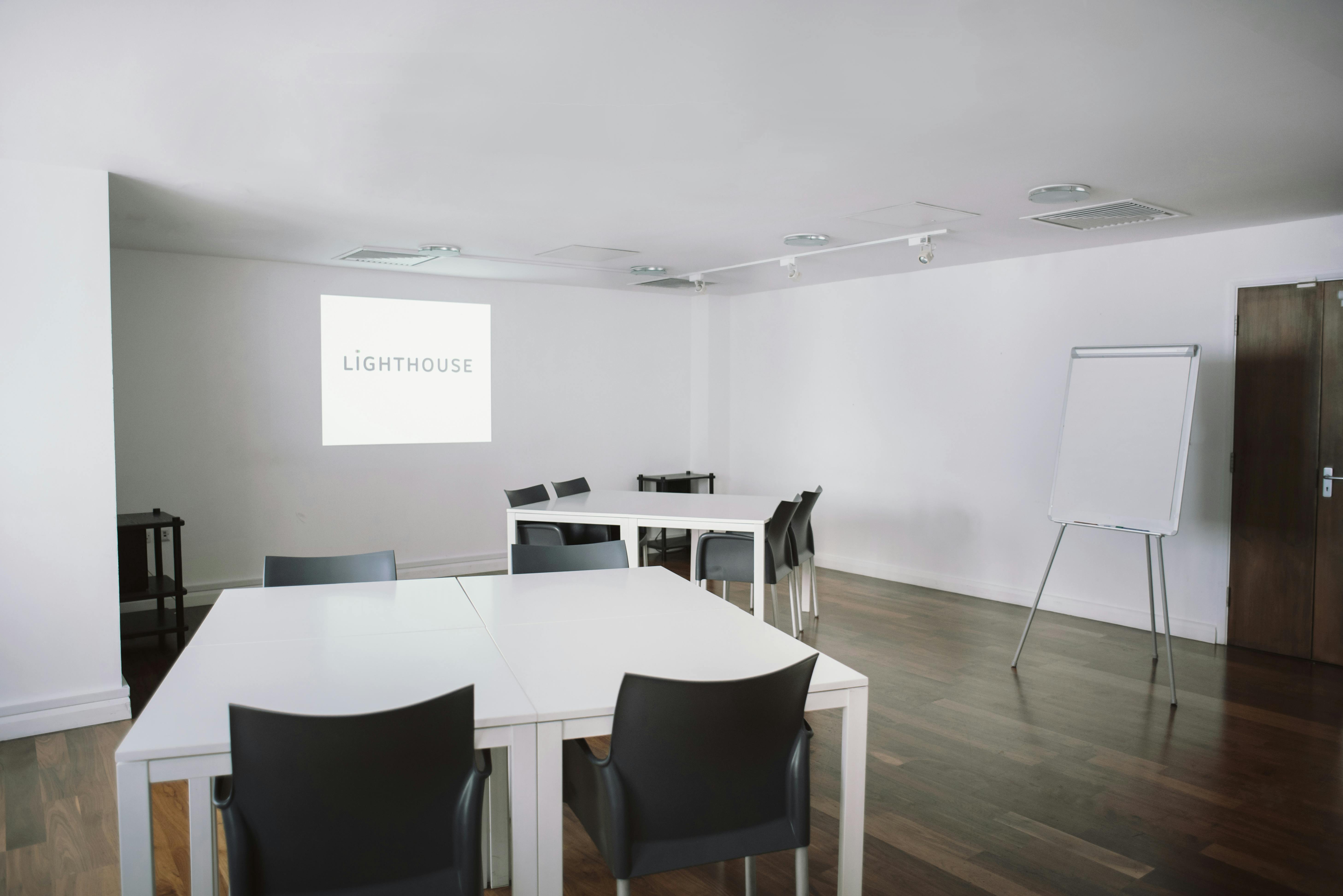 Modern conference room with projector screen, ideal for corporate meetings and workshops.