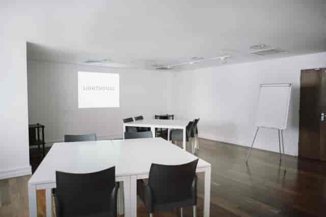 Modern conference room with projector screen, ideal for corporate meetings and workshops.