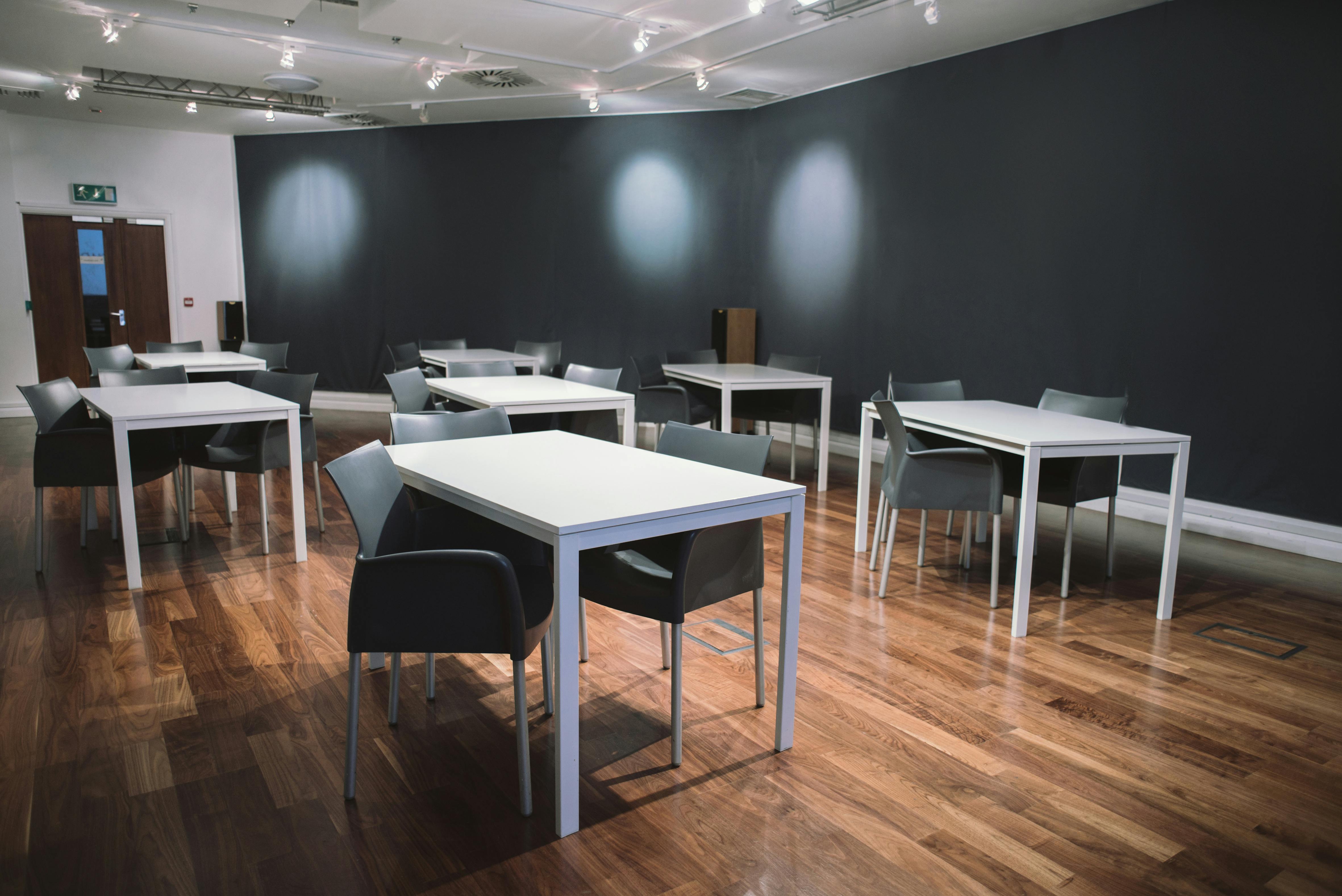 Digital Lounge meeting space with white tables, ideal for workshops and brainstorming sessions.