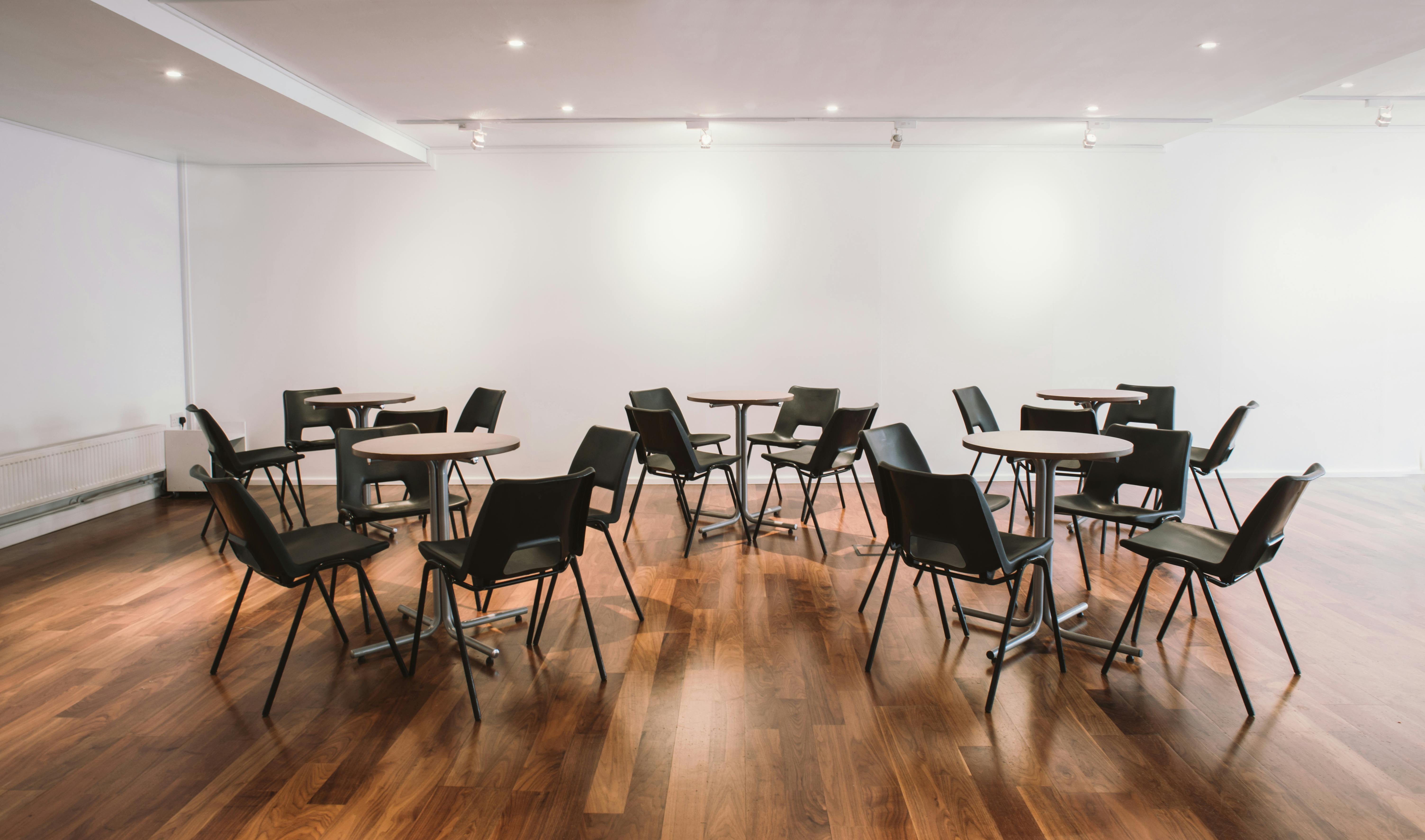 Reception area in Lighthouse with round tables, ideal for networking events and workshops.