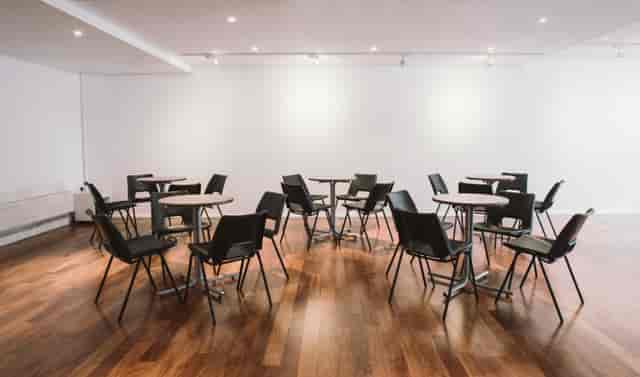 Versatile reception area with round tables, ideal for networking events and workshops.