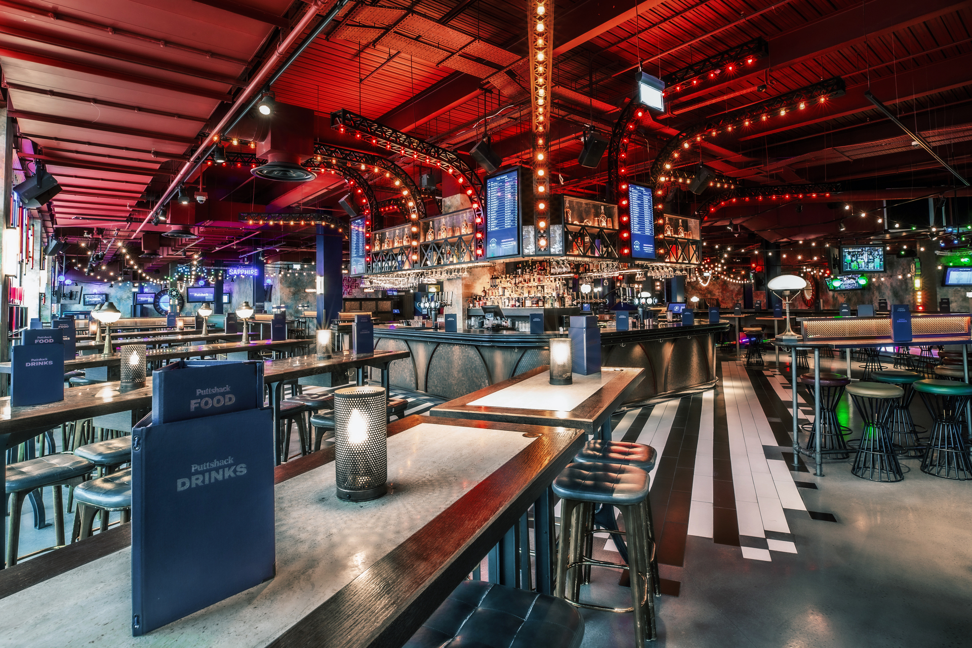 Christmas event venue with stylish seating and ambient lighting at Puttshack White City. - Banner