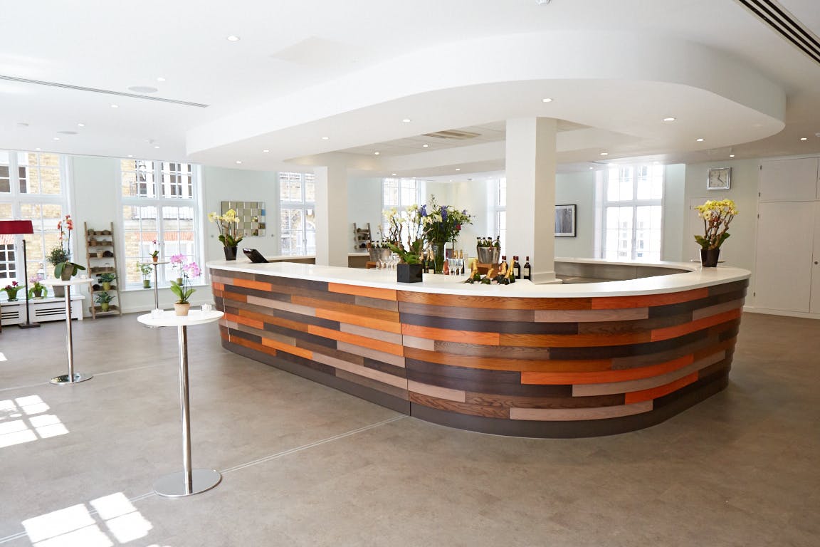 Modern reception area with curved wooden counter at The Green House, ideal for events.