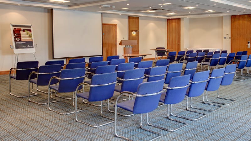 Meeting space at Holiday Inn High Wycombe with blue chairs for conferences and workshops.