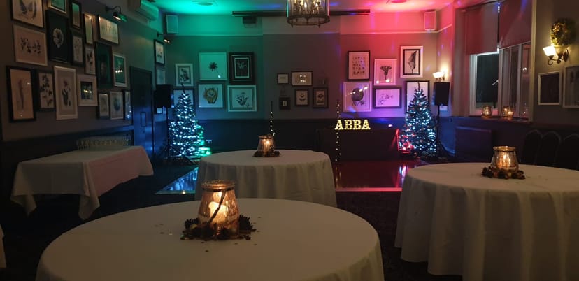 Dulwich Suite event space, festive ambiance with ABBA theme and vibrant lighting.