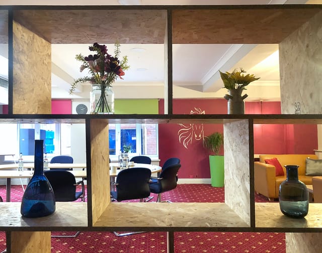 Modern meeting room with open shelving, ideal for workshops and brainstorming sessions.