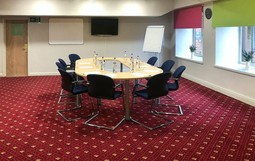 Meeting room with oval table and natural light for productive business events.