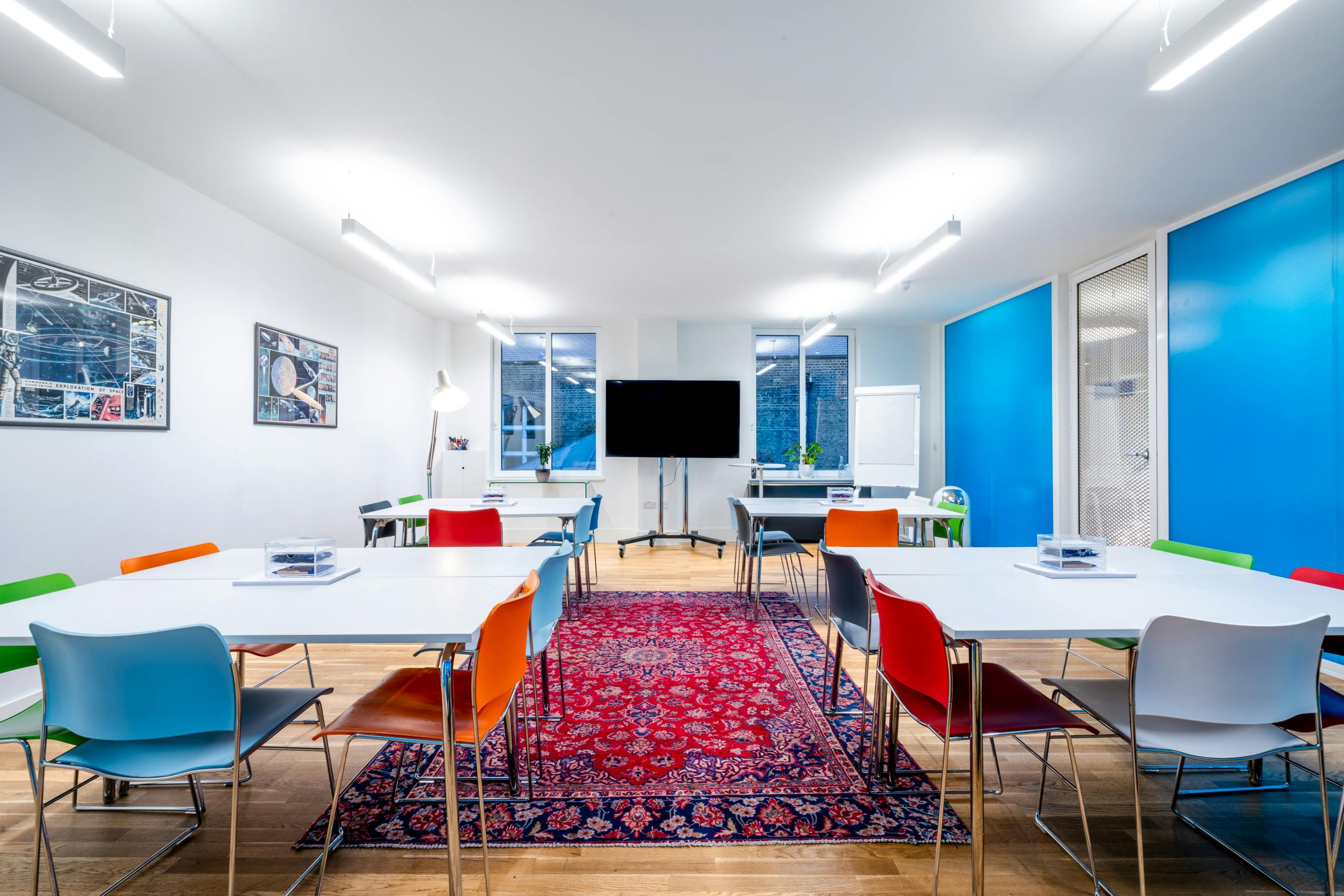 Modern meeting room with colorful chairs, ideal for workshops and brainstorming sessions.