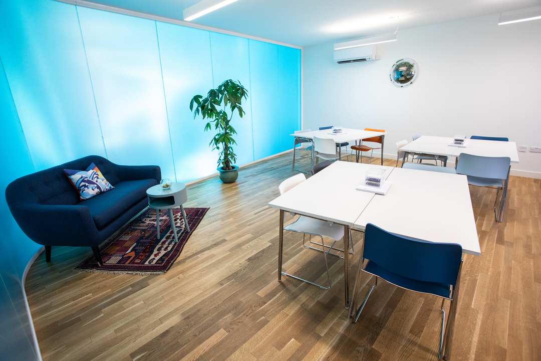 Valentina in a modern, airy meeting space with blue lighting for workshops and team meetings.