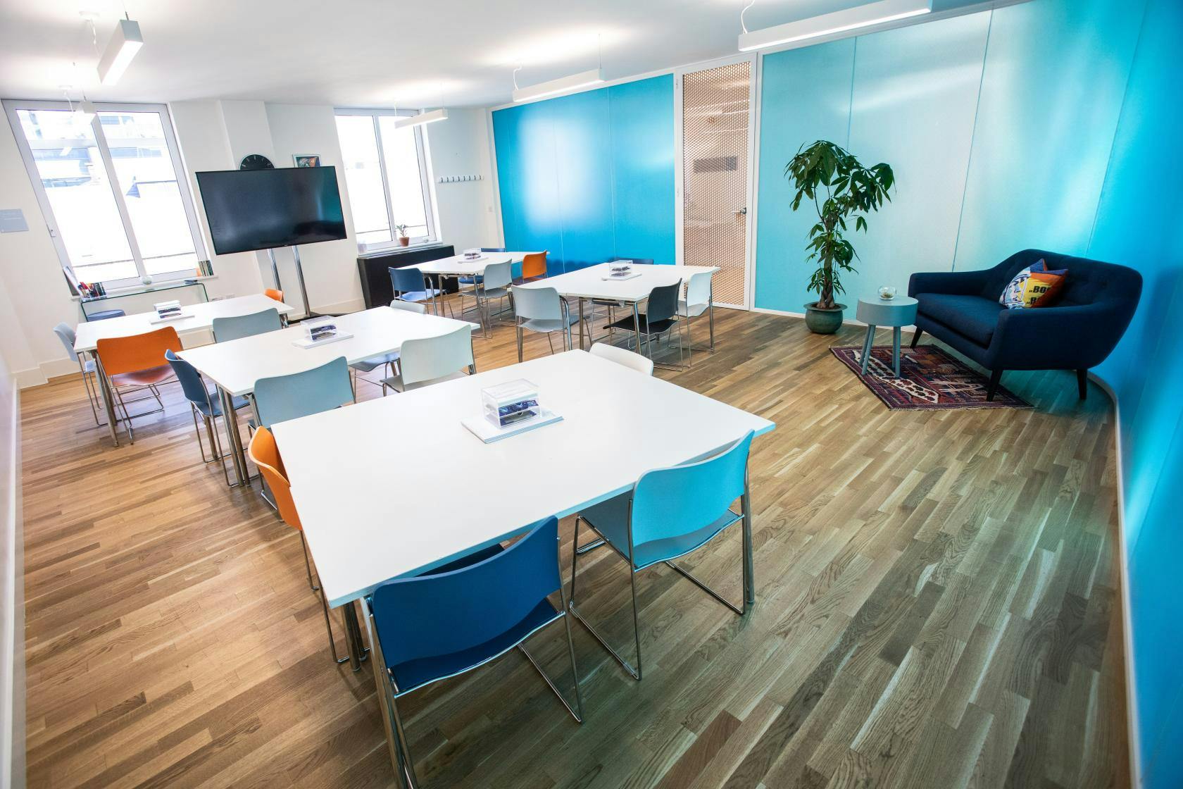 Valentina in a vibrant blue meeting space, perfect for workshops and collaboration.