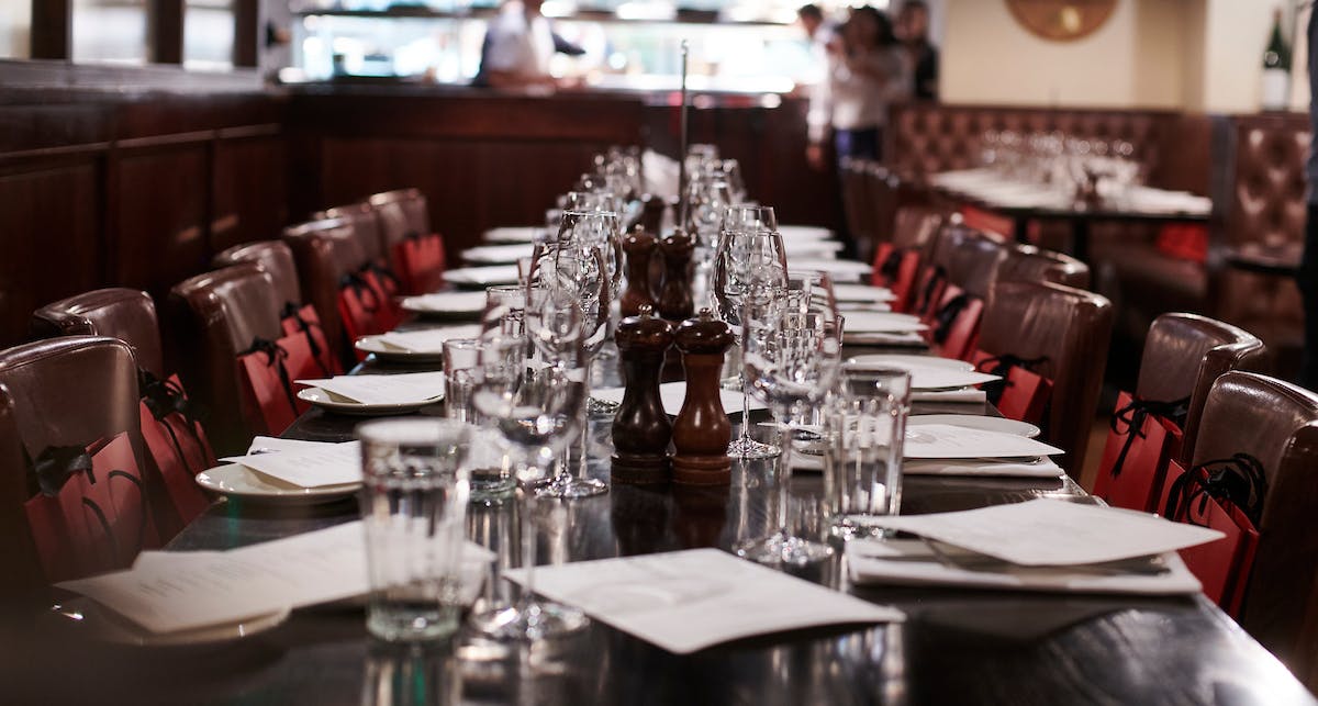 Elegant dining table setup in semi-private space for intimate gatherings or business dinners.