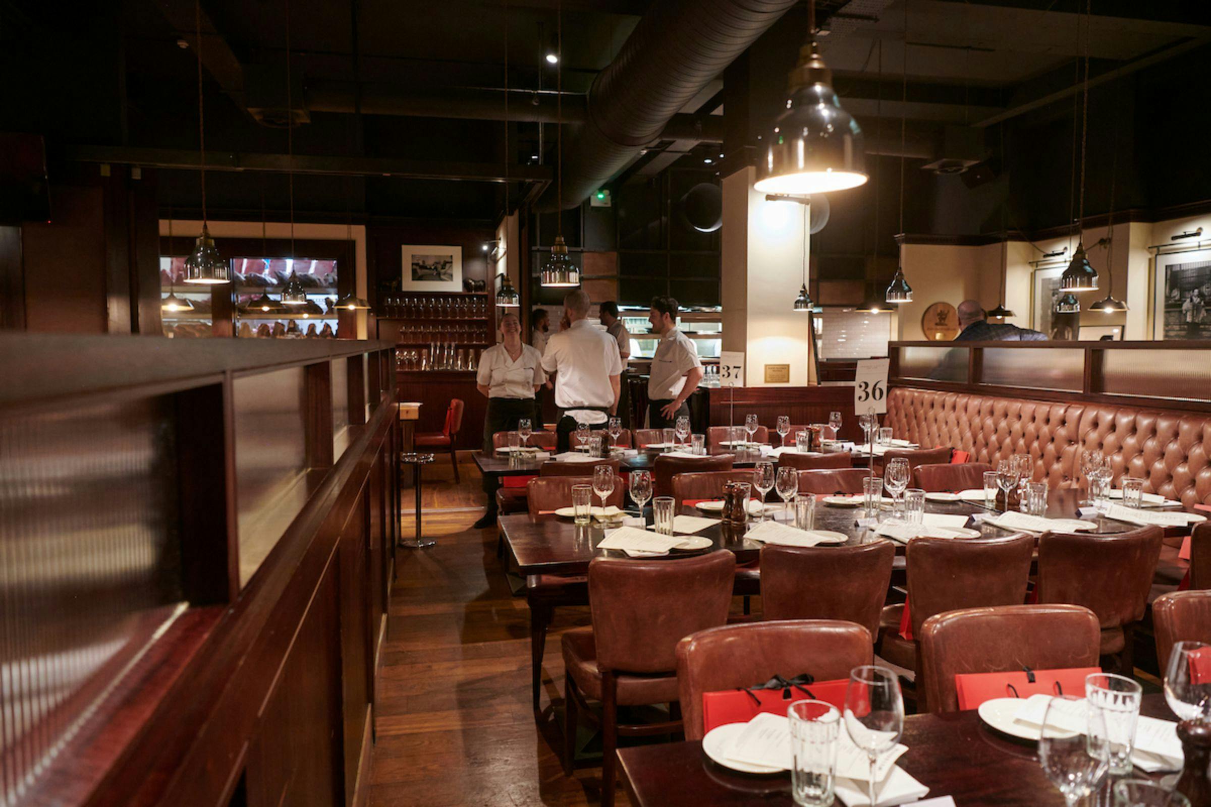 Semi-private restaurant space with elegant table settings for corporate dinners and events.