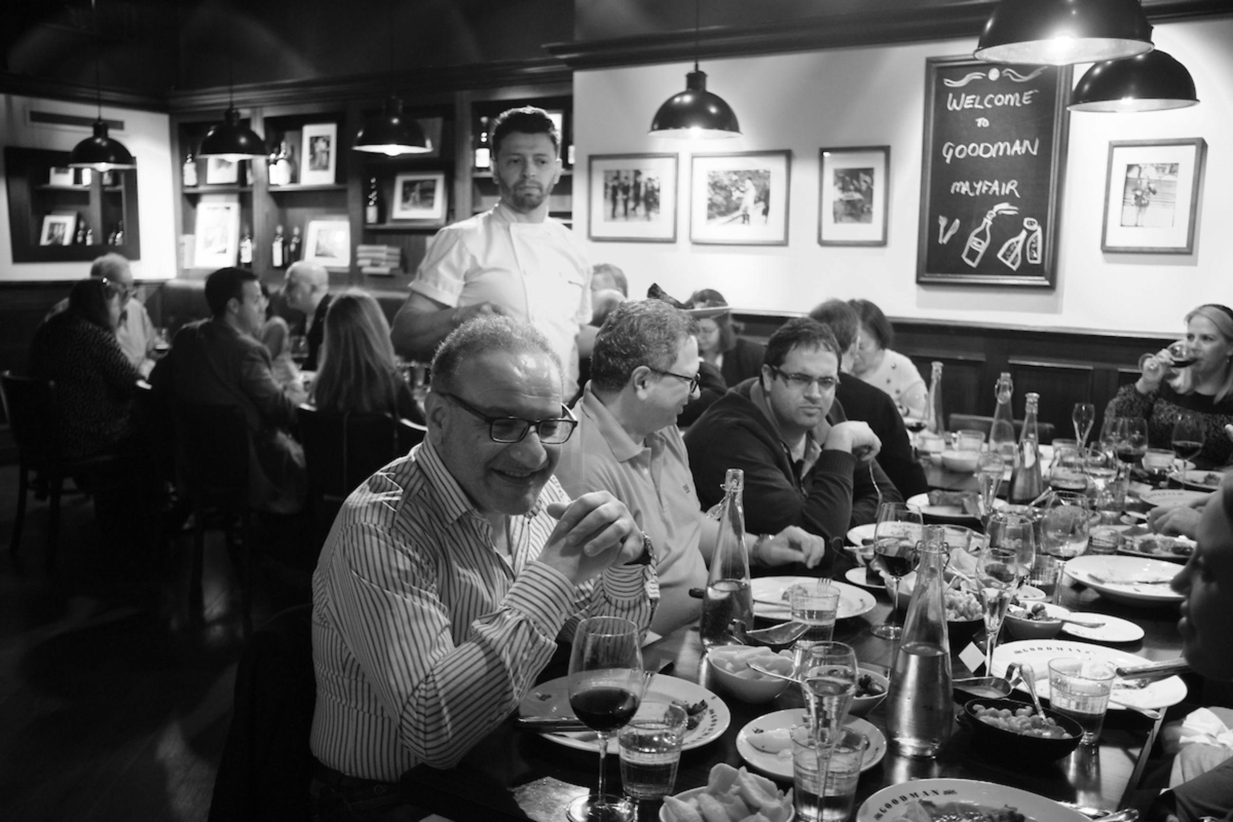 Lively dining event at Goodman Mayfair with elegantly set tables and warm ambiance.