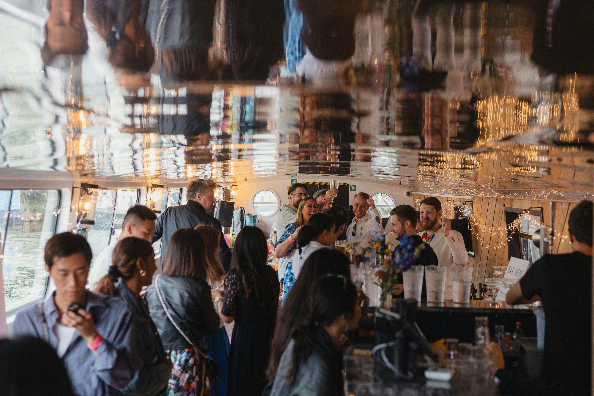 Vibrant networking event on Mary Read Boat with artistic ceiling reflections.