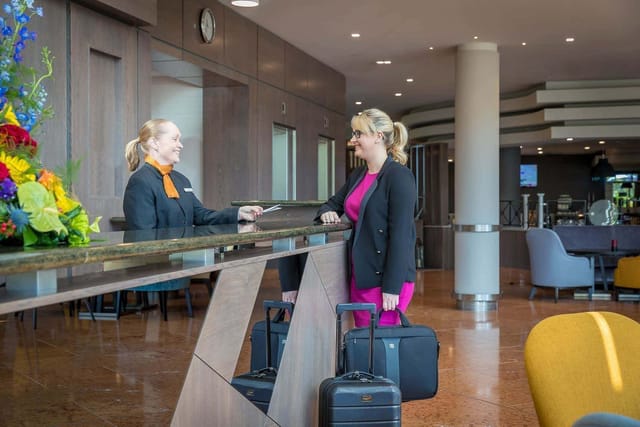 "Welcoming hotel reception at Maldron Hotel Belfast with elegant floral arrangement."