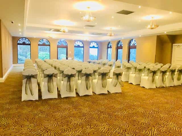 Elegant event space in Gleddoch Hotel with draped chairs, perfect for conferences or weddings.