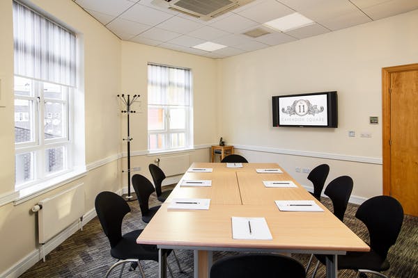 Well-lit meeting room with central table and ergonomic chairs for collaborative events.