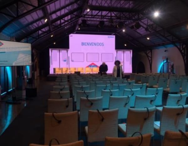 Event space at Museo del Ferrocarril with welcoming stage and arranged chairs for networking.
