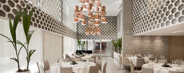 Modern meeting space with elegant tables and copper chandelier at HOTEL NH EUROBUILDING.