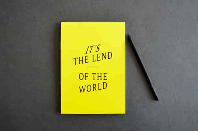 Vibrant yellow notebook and black pen for creative event planning at Lendhotel.