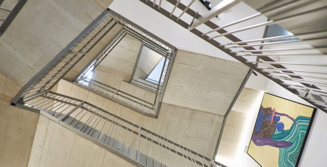 Modern staircase with metal railings at Lendhotel venue for networking events.